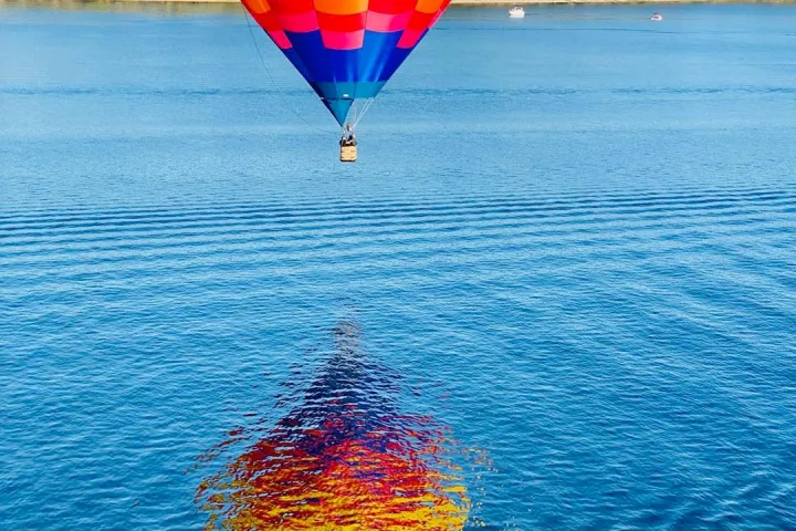 a large balloon in front of a body of water